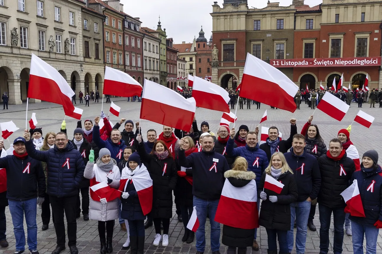 Défilé du 11 novembre en Pologne, drapeaux blanc-rouge, foule festive sur la place d'une ville polonaise